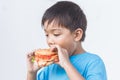 AsianÃ¢â¬â¹ childÃ¢â¬â¹ boyÃ¢â¬â¹ biting andÃ¢â¬â¹ eatingÃ¢â¬â¹ aÃ¢â¬â¹ hamburger.Ã¢â¬â¹ Fast food.Ã¢â¬â¹ KidÃ¢â¬â¹ andÃ¢â¬â¹ healthyÃ¢â¬â¹ concept.Ã¢â¬â¹ OnÃ¢â¬â¹ white